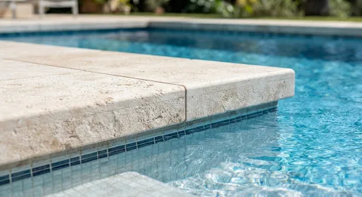 Detalle de coronación de piscina en gres porcelánico con juntas precisas y agua cristalina