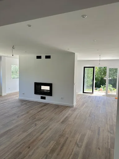 Renovación interior de alto nivel mostrando una habitación moderna y espaciosa en obra con luz natural